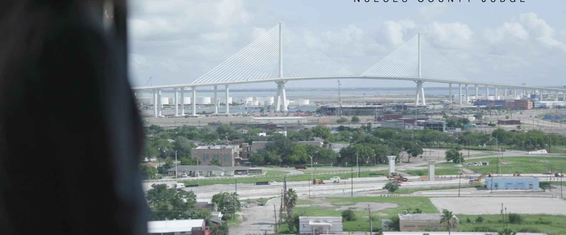 Judge Connie Scott at a courthouse window with the new Harbor Bridge visible over the port of Corpus Christi